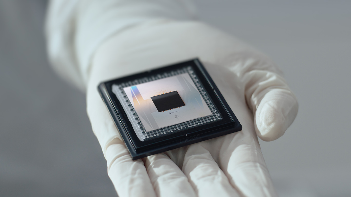 क्वांटम 'इको' से गूगल के क्वांटम कंप्यूटर की क्षमता का A gloved hand holds a shiny metallic quantum computing chip.