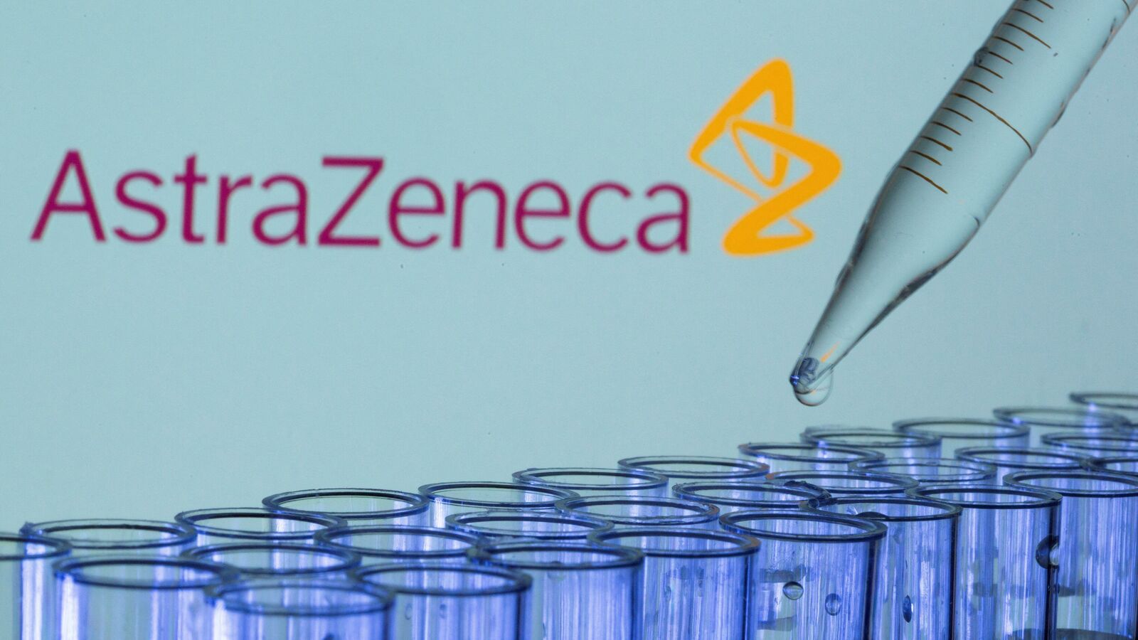 Test tubes are seen in front of a displayed AstraZeneca logo in this illustration taken, May 21, 2021.